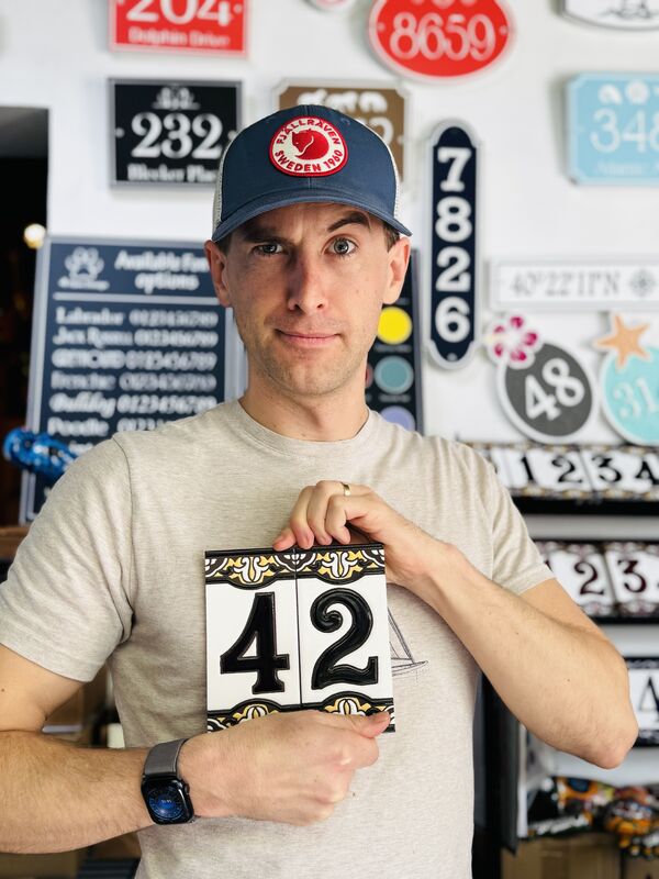 Skylar Bolton holding ceramic house-number tiles reading 42